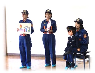 幼稚園などで紙芝居で防災啓発を行う女性消防団員の画像
