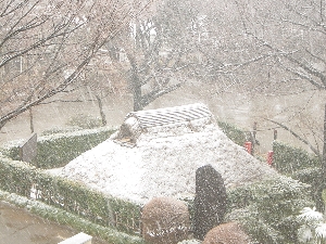 雪の降る中の古代住居