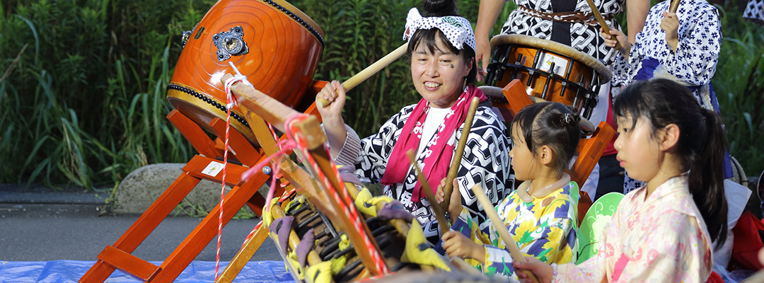 夏まつりで子どもたちに太鼓をレクチャー