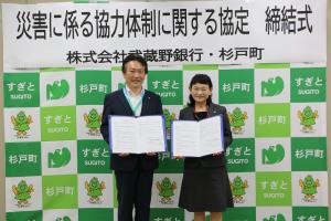 協定書を持つ、杉戸町の窪田町長（左）と株式会社武蔵野銀行杉戸高野台支店長の川端支店長（右）